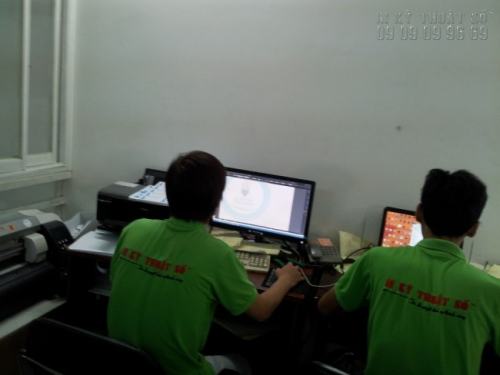 Nhân viên thiết kế hỗ trợ khách hàng kiểm tra file thiết kế trước khi chạy đơn hàng in