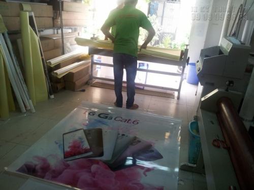 Nhân viên gia công cán màng backlit film làm hộp đèn quảng cáo trung tâm thương mại