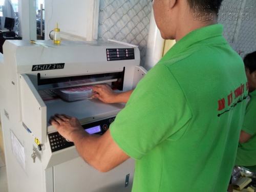 Nhân viên InKyThuatSo đang gia công cắt tem decal trong bằng máy cắt lazer 