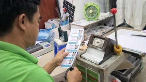 Nhân viên in ấn của InKyThuatSo đang gia công thẻ nhựa cho khách hàng sau khi in xong thẻ nhựa